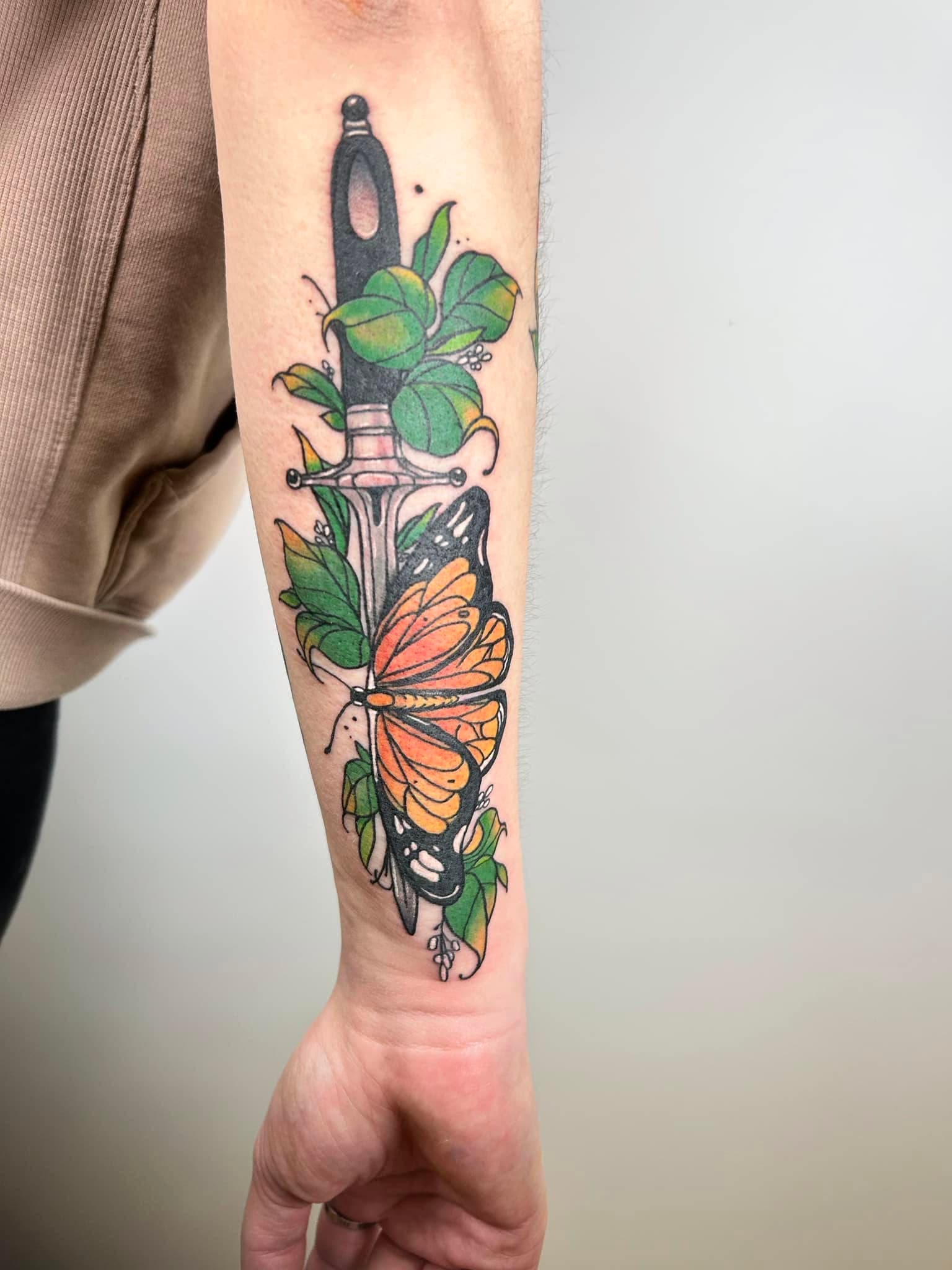 Tatouage néo-traditionnel en couleur d'une dague avec papillon